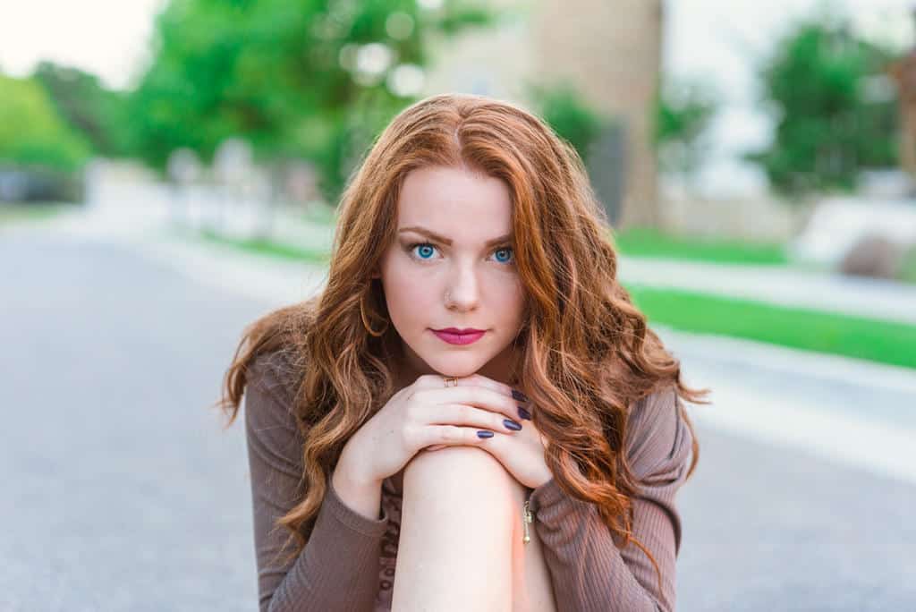 Senior portraits, Tulsa, downtown, gold hoops, red hair, brown cardigan, floral spaghetti strap, mauve lipstick, blue eyed girl